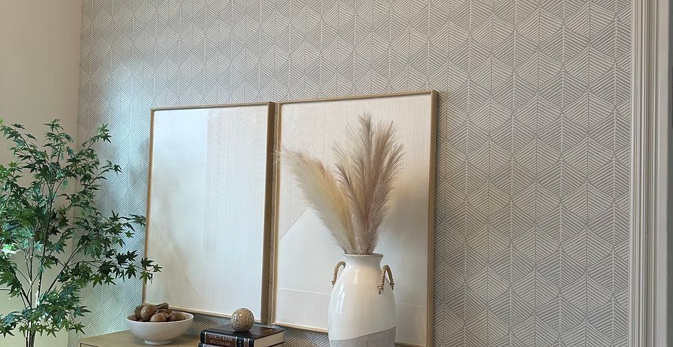 Neutral geometric grasscloth wallpaper behind a styled entry vignette