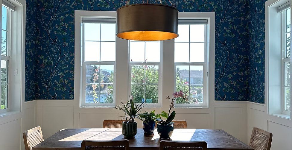 Navy chinoiserie floral and bird wallpaper in a bright dining nook